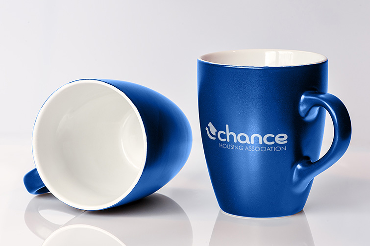 Brand Identity - Merchandise - Graphic Design - Mockup of coffee mugs with logo printed on them.