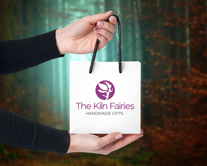Brand Identity - Packaging Design - Mockup of person holding up a small gift bag with logo and streamline printed on it.